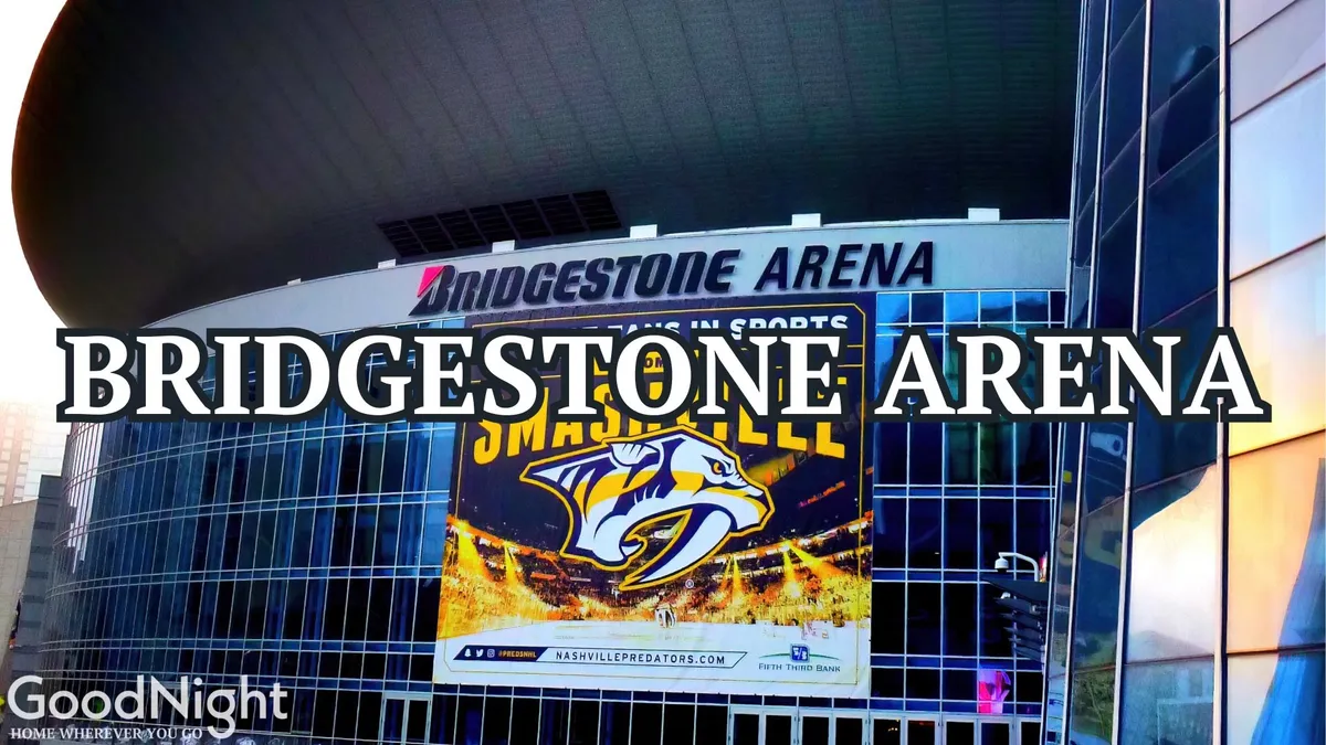 A dynamic exterior view of Bridgestone Arena, featuring its prominent sign and a large promotional banner for the Nashville Predators. Crowds and the unique curved architecture highlight its status as a hub for concerts and sporting events in downtown Nashville.
